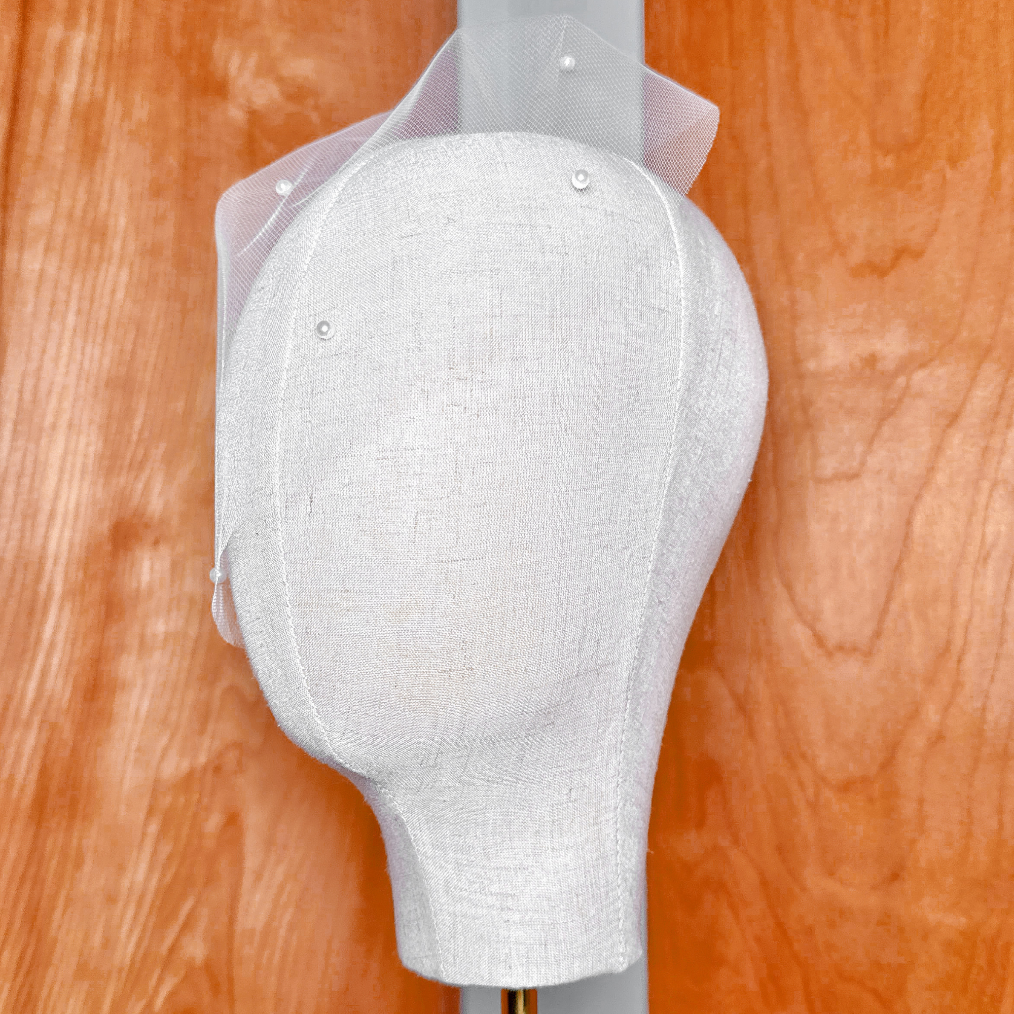 Side view profile showing the shape and drape of the mini tulle birdcage wedding veil with scattered pearls.