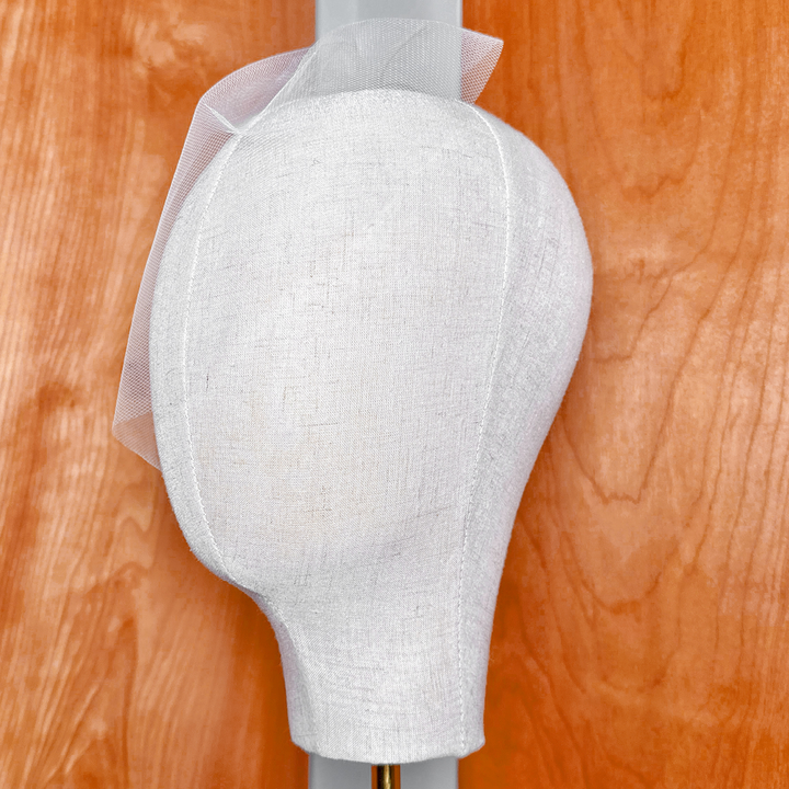 Side profile view of a mini tulle birdcage wedding veil illustrating how the lightweight netting drapes elegantly over the face.