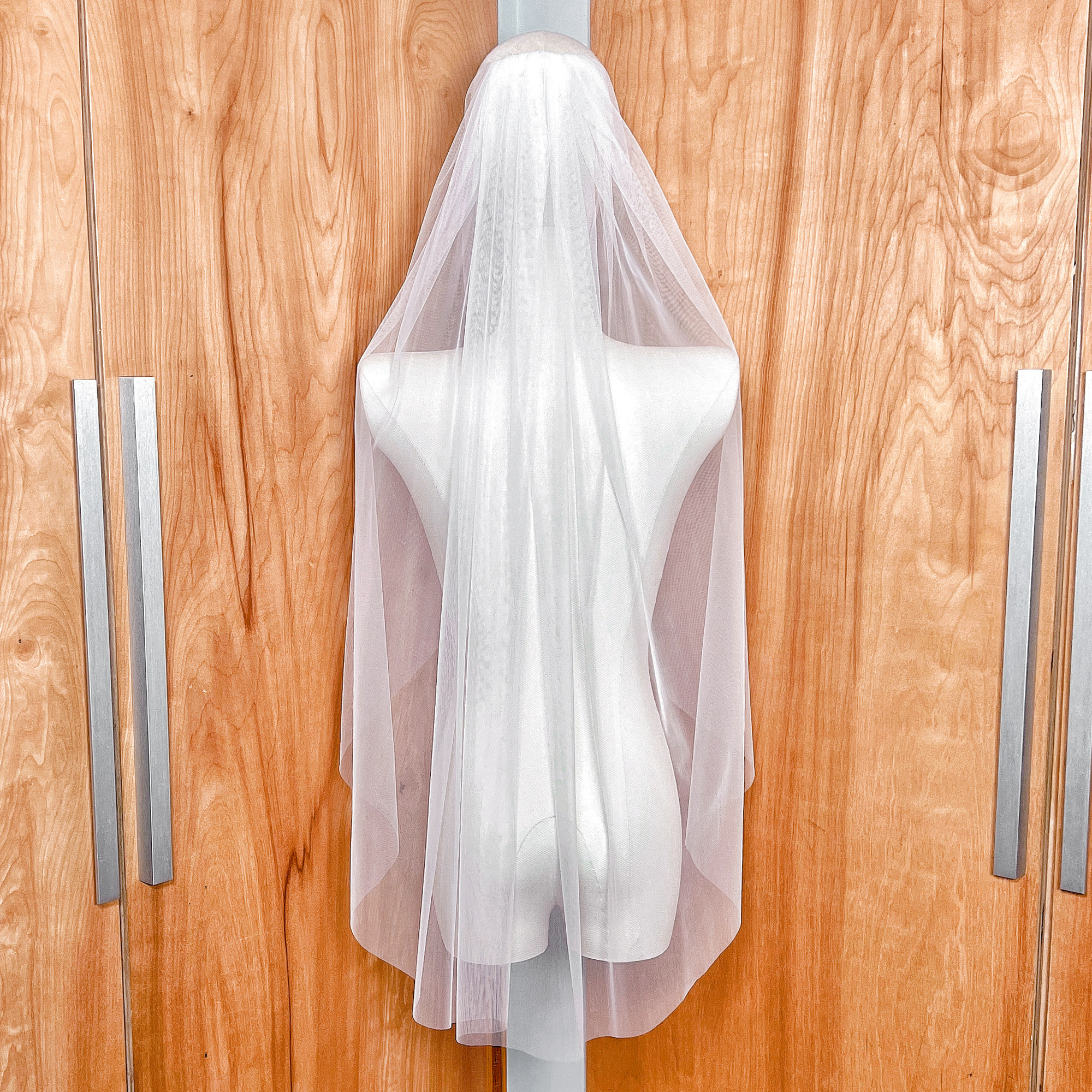 Rear view of a minimalist raw edge fingertip veil showing the elegant single-tier drape.