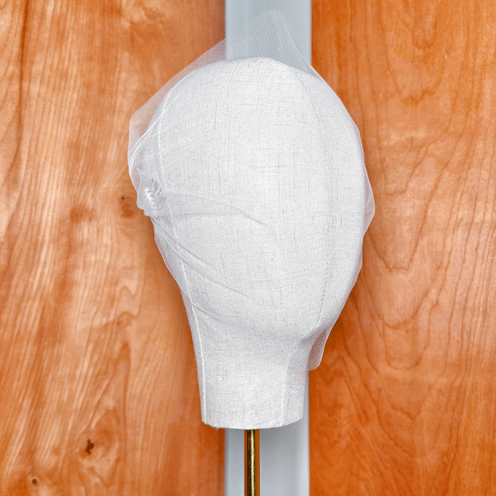 Minimalist style tulle bandeau wedding veil shown on a display mannequin.