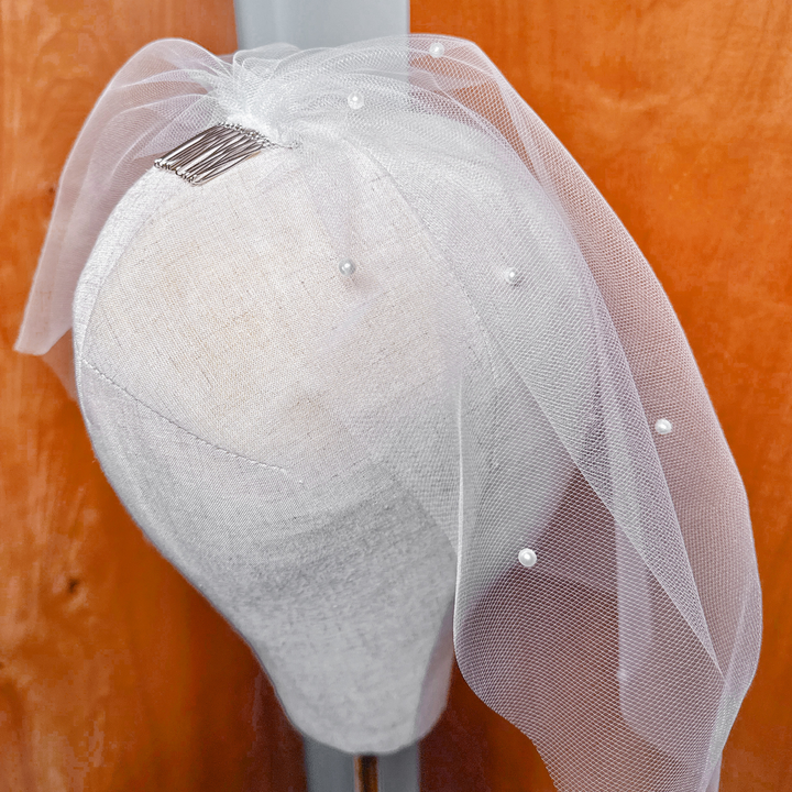 Back view showing how the pearl birdcage wedding veil secures with its metal comb.