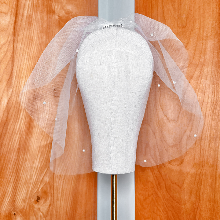 Top-down angle view highlighting the placement of a pearl birdcage wedding veil.
