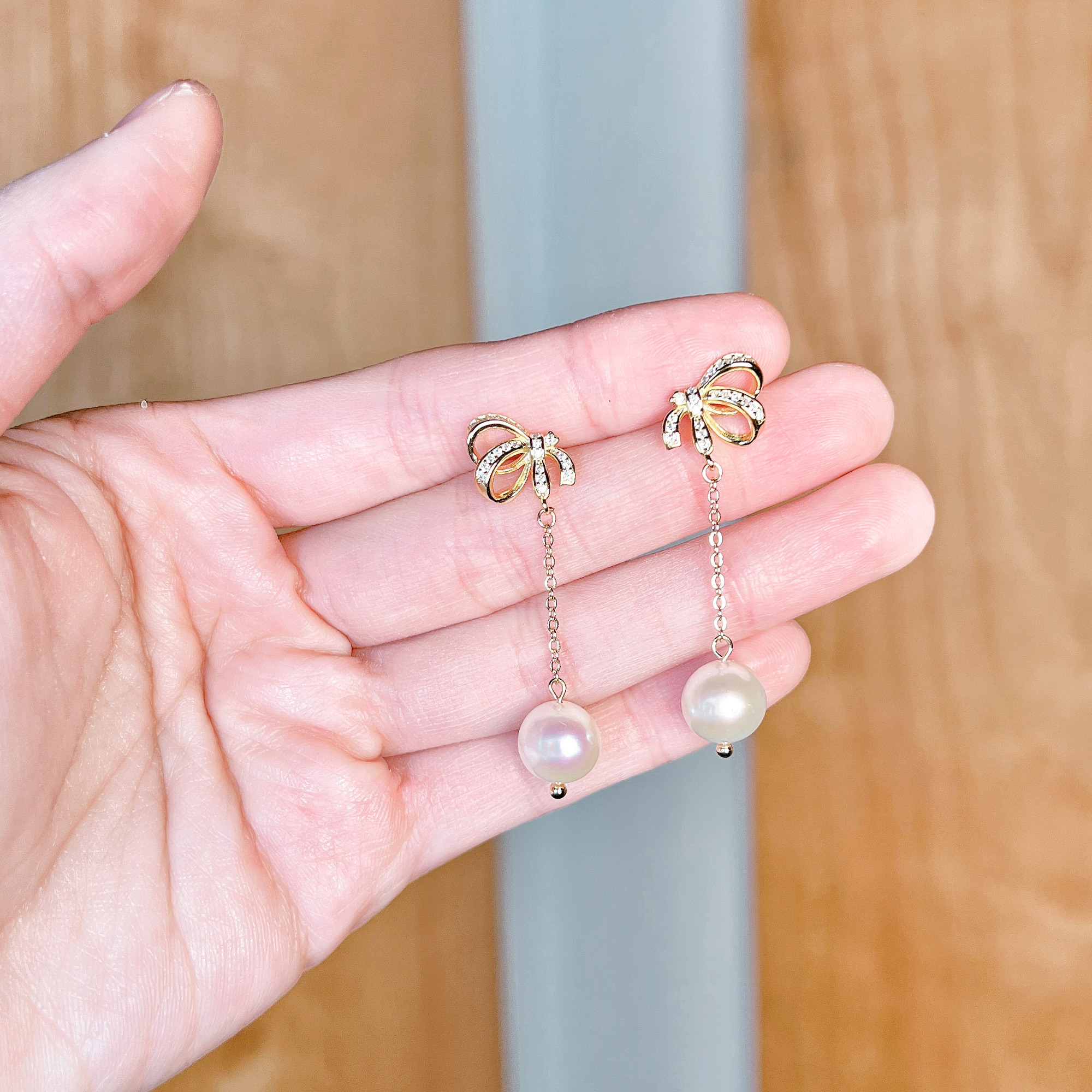 Macro view showing the intricate ribbon design of pearl bowknot dangle earrings for wedding.