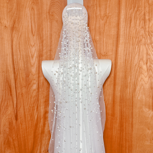 Close-up of the delicate pearl embellishments on a cathedral length mantilla bridal veil.