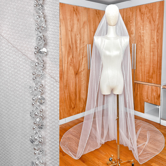 Cathedral length wedding veil featuring a delicate pearl trim edge on soft ivory tulle.