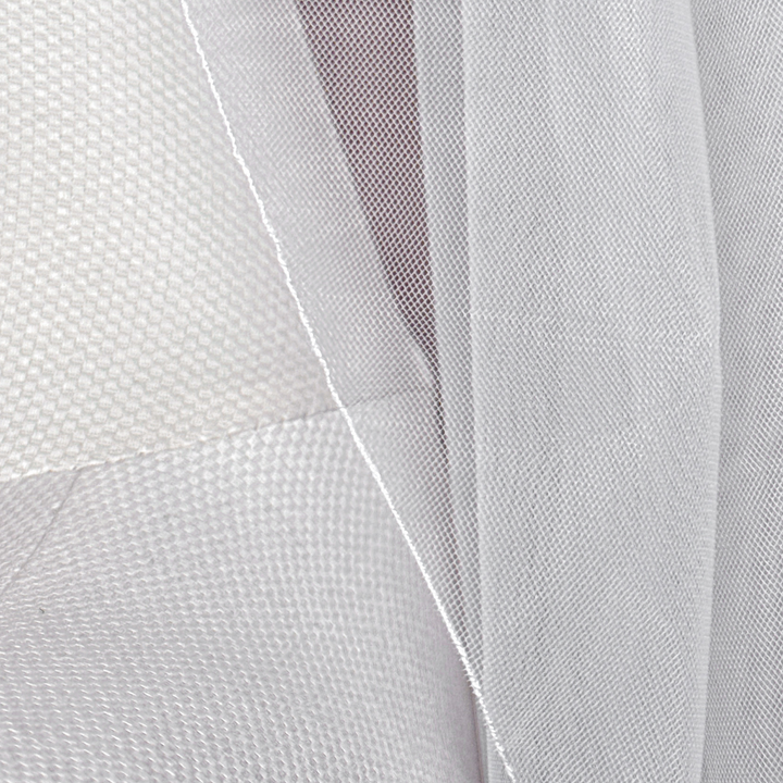 Close-up of a cascade shoulder length wedding veil featuring a delicate pencil edge on a mannequin torso.