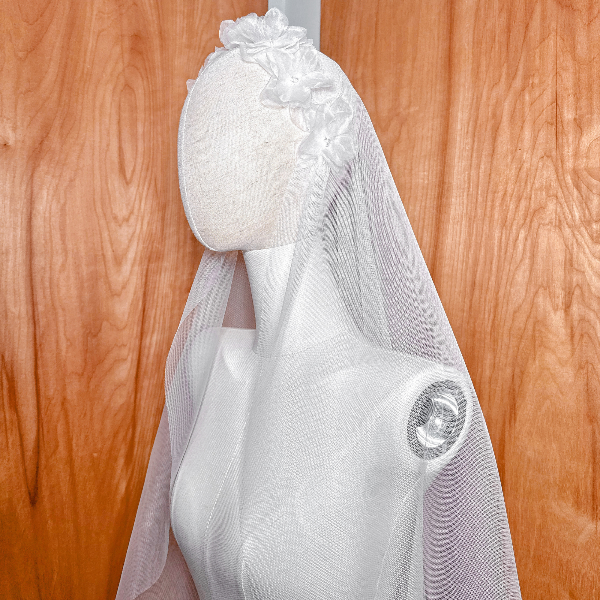 Side view of a 3D silk organza flower Juliet cap veil on a mannequin, showing the graceful waltz length drape.