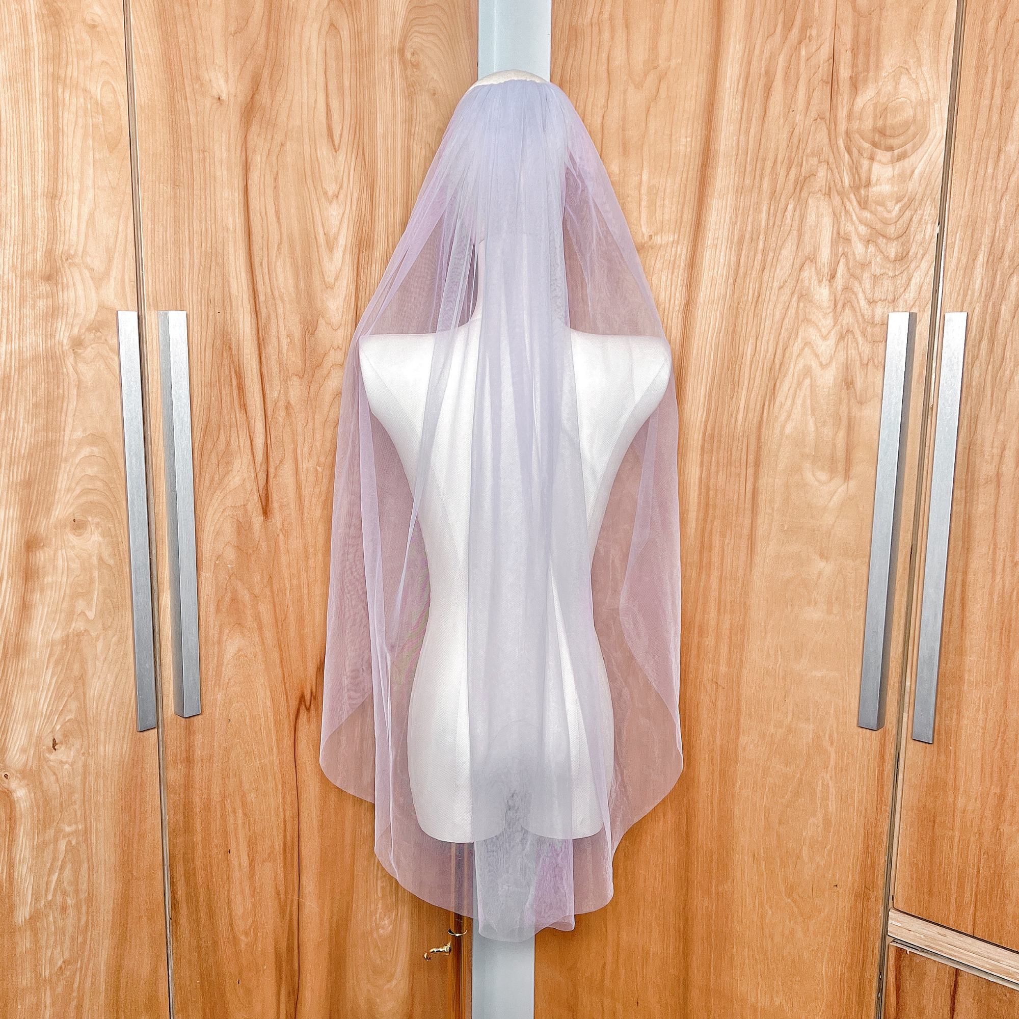 A fingertip length purple wedding veil featuring a secure silver metal comb for easy styling.