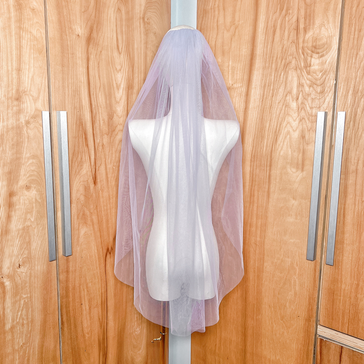 A fingertip length purple wedding veil featuring a secure silver metal comb for easy styling.