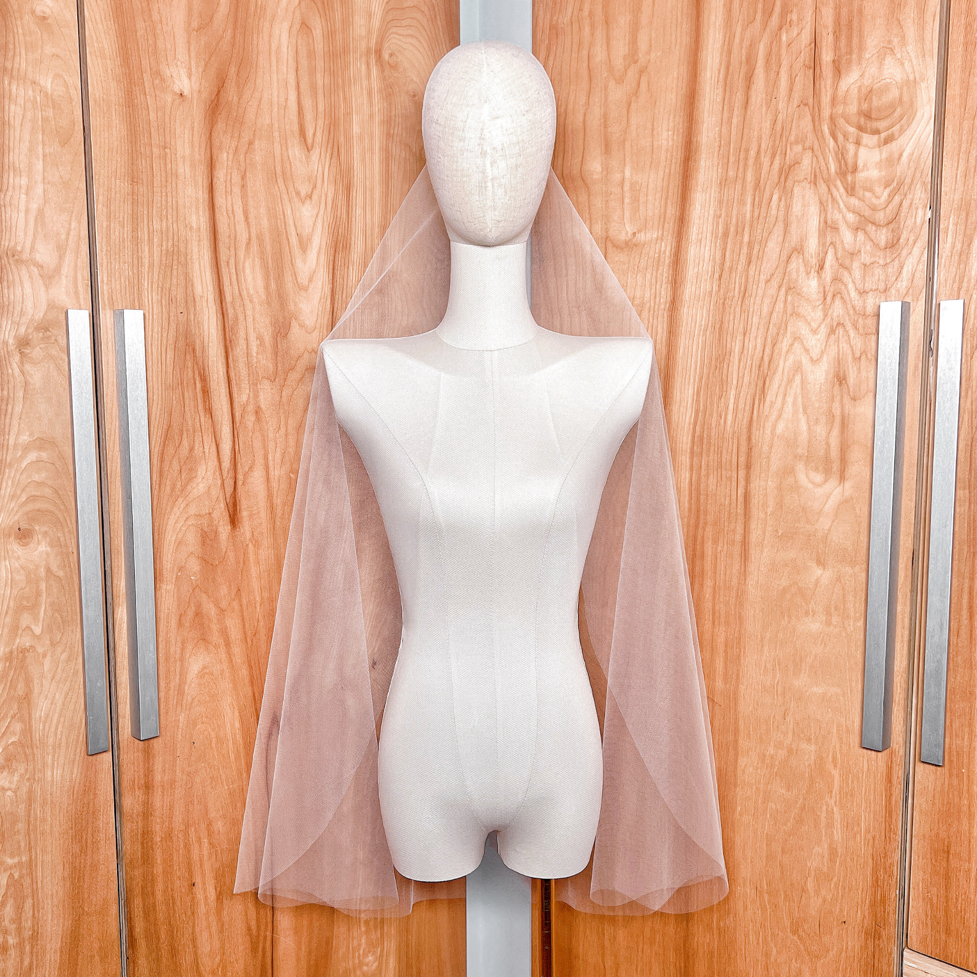 Minimalist barely there fingertip wedding veil with a raw edge finish, highlighting the transparent bridal illusion tulle.