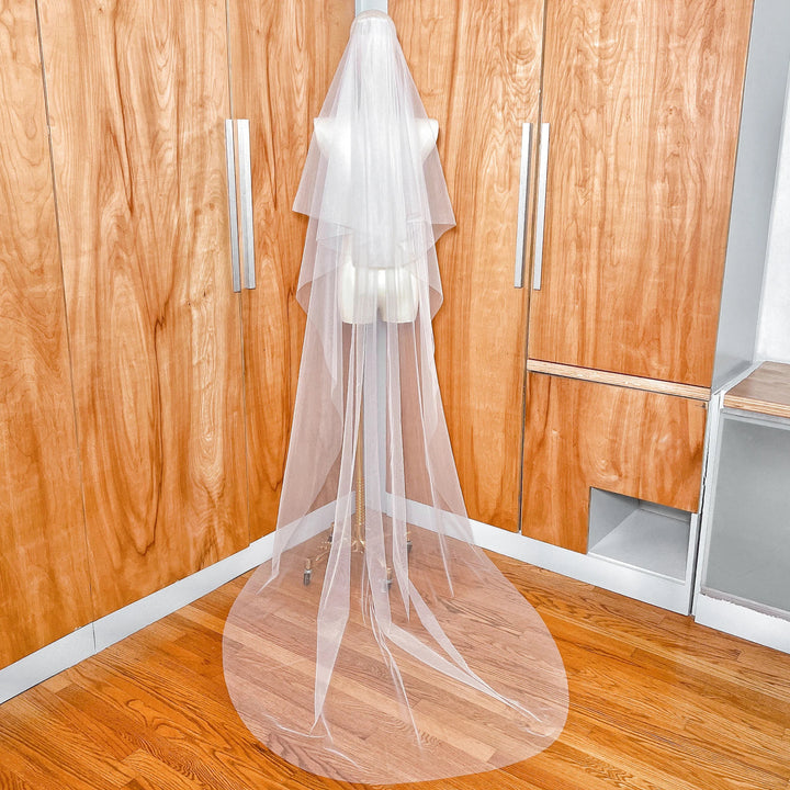 Close-up detail of the soft ivory tulle and precise raw edge finish on a two-tier chapel length wedding veil.
