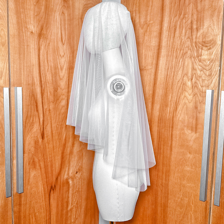 Side profile of a two tier elbow length veil showing the layered raw edge tulle and blusher.
