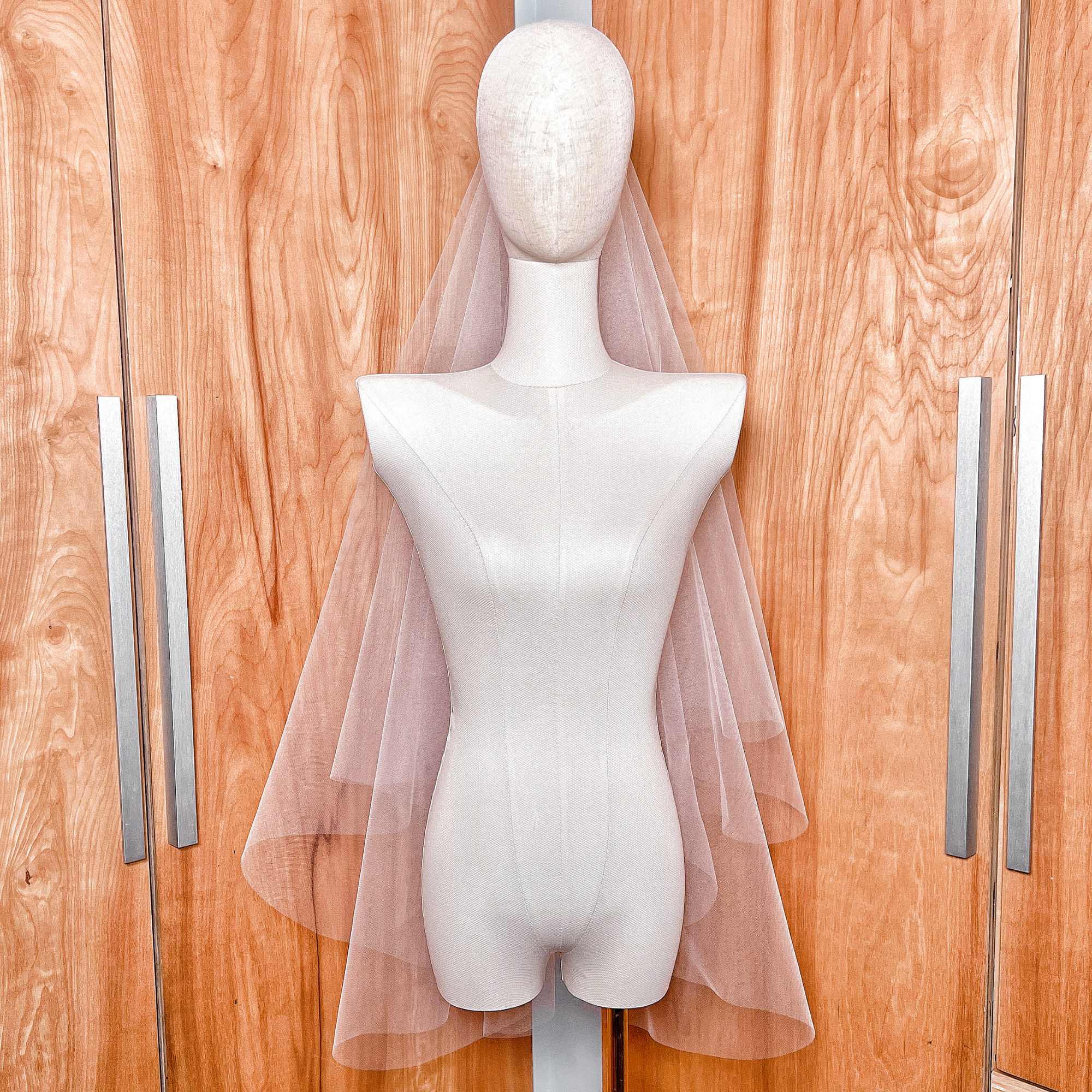 Elegant two-tier fingertip length veil with a raw cut edge and traditional bridal blusher.