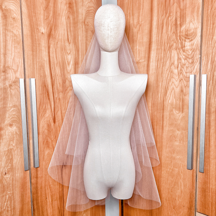 Elegant two-tier fingertip length veil with a raw cut edge and traditional bridal blusher.