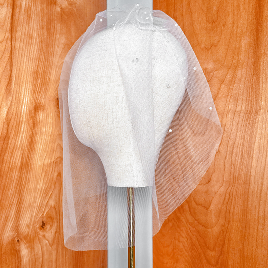 Back view focusing on the hair comb securing the pearl birdcage wedding veil.