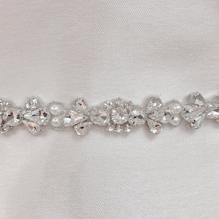 Detailed close-up view of the shimmering crystals and pearls on the rhinestone and pearl bridal belt.