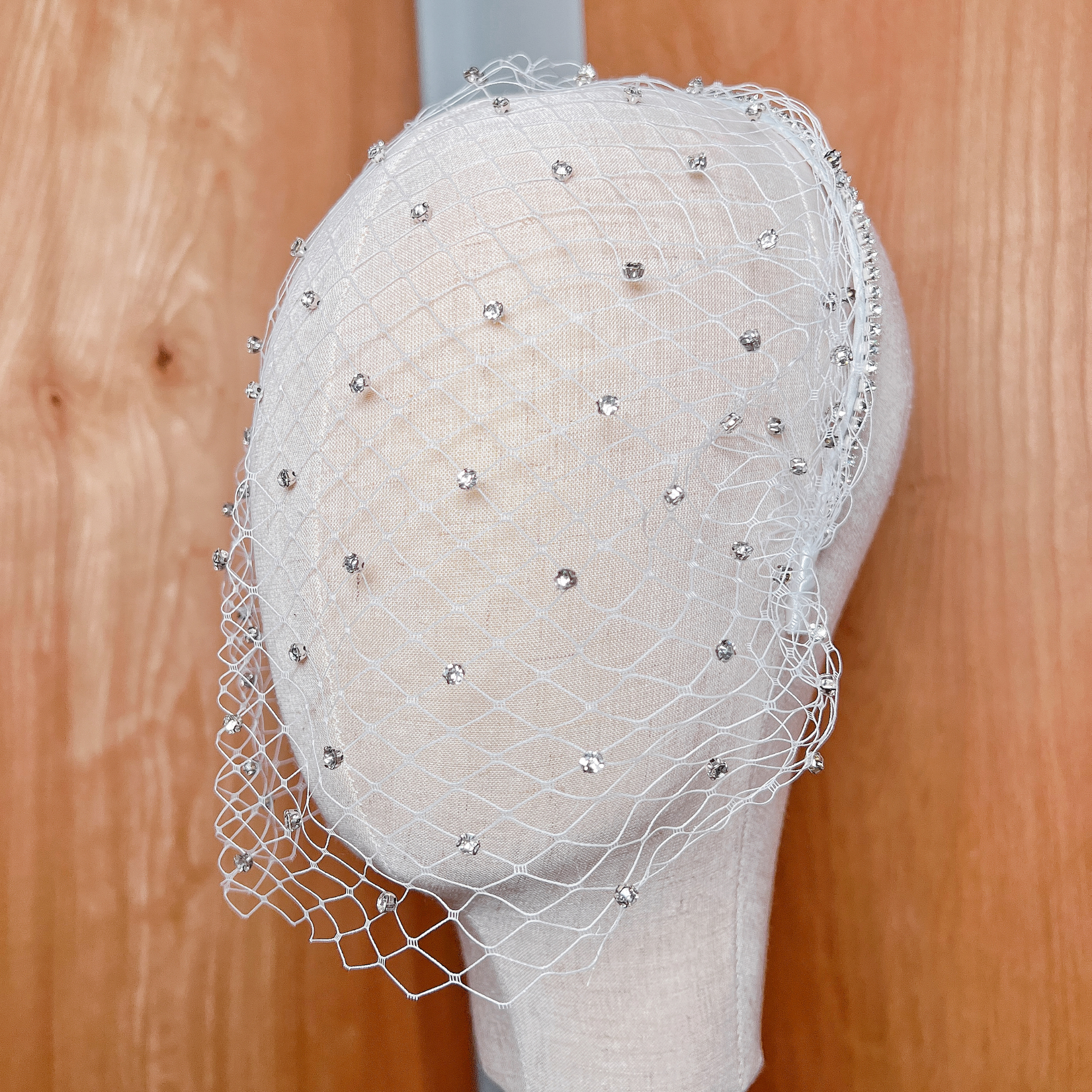 Close-up shot showing the detailed netting and sparkling crystals of the rhinestone birdcage wedding veil.