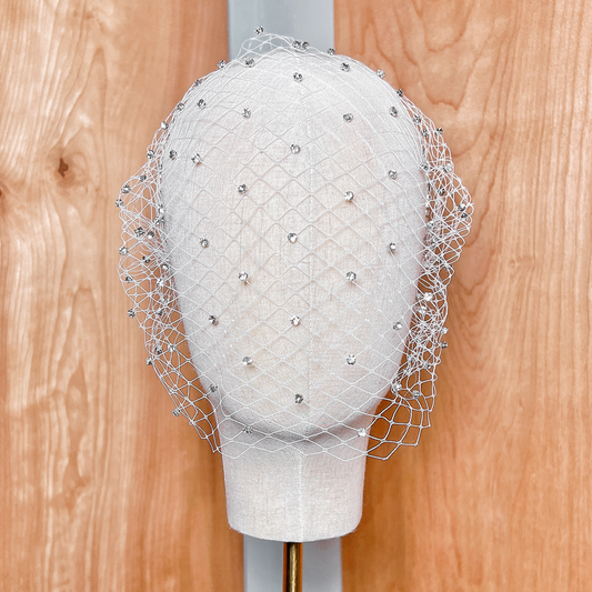 Front view of a classic rhinestone birdcage wedding veil displayed on a bridal bust.
