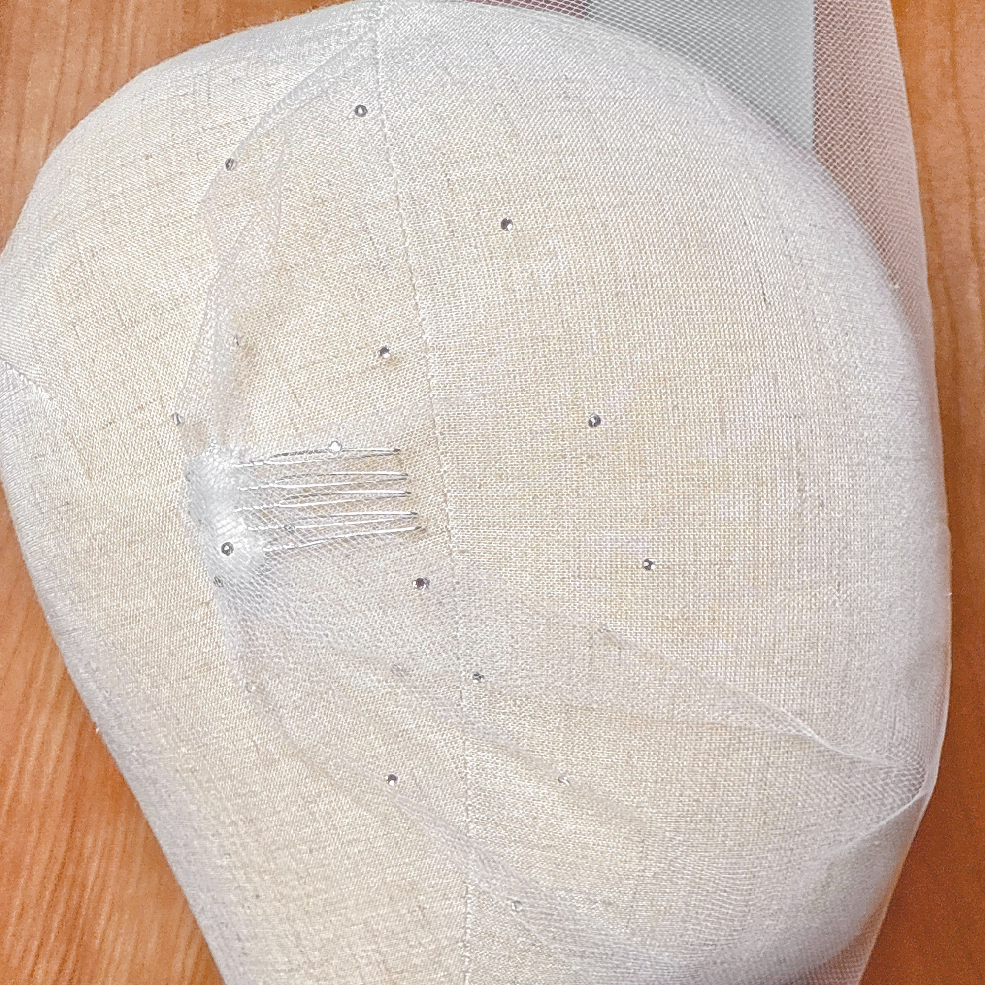 Close-up view of the sparkling rhinestone accents on a sheer tulle bandeau wedding veil.