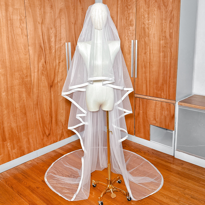 1 inch ribbon edge cathedral length wedding veil with a blusher draped on a mannequin.