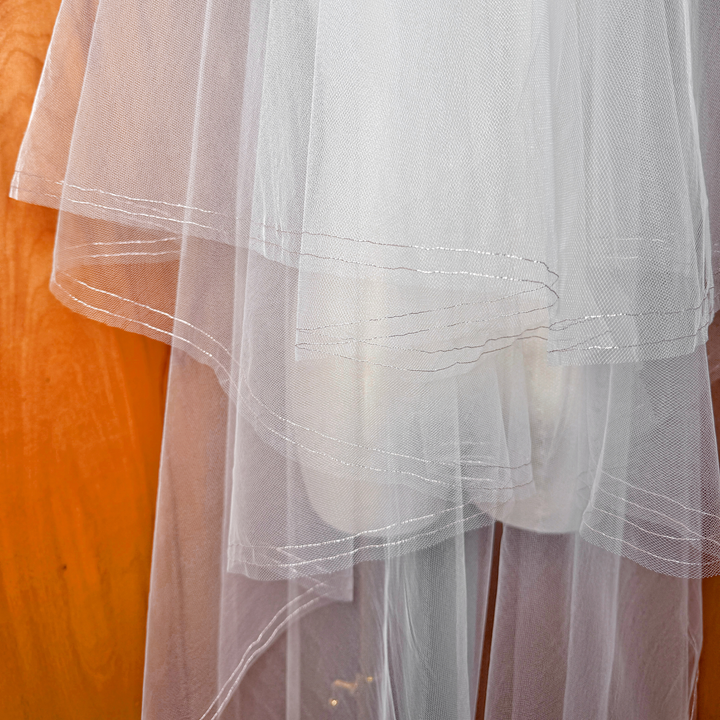 Detailed close-up of the rose gold metallic edge on a two tier wedding veil with blusher.
