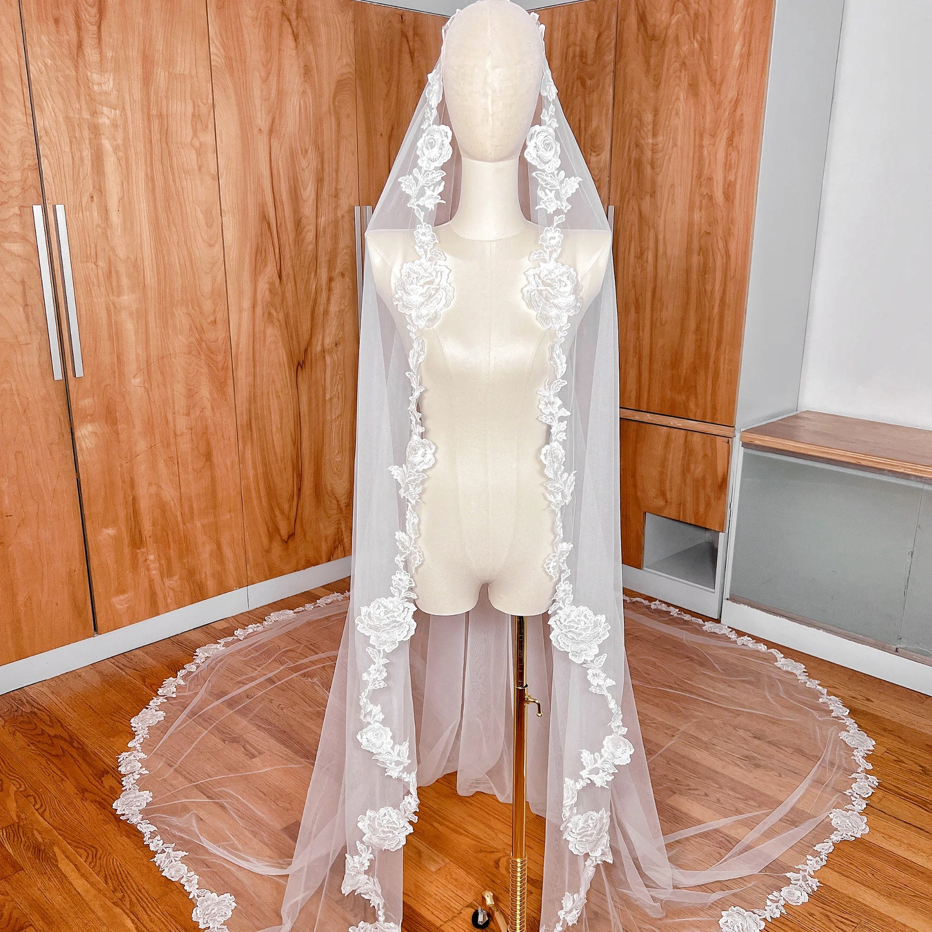 Front view of a floral lace mantilla wedding veil in royal cathedral length displayed on a professional bridal mannequin.