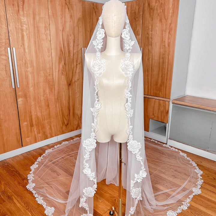 Front view of a floral lace mantilla wedding veil in royal cathedral length displayed on a professional bridal mannequin.