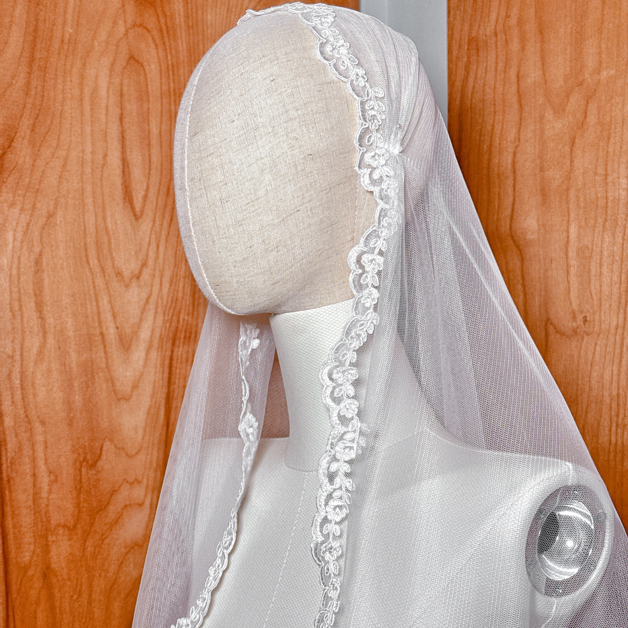 Close-up of the scalloped Alençon lace edge on a fingertip length bridal veil.