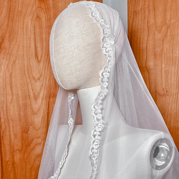 Close-up of the scalloped Alençon lace edge on a fingertip length bridal veil.