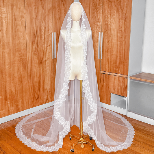 Cathedral length Chantilly lace mantilla veil with a detailed scalloped eyelash lace edge on a mannequin.