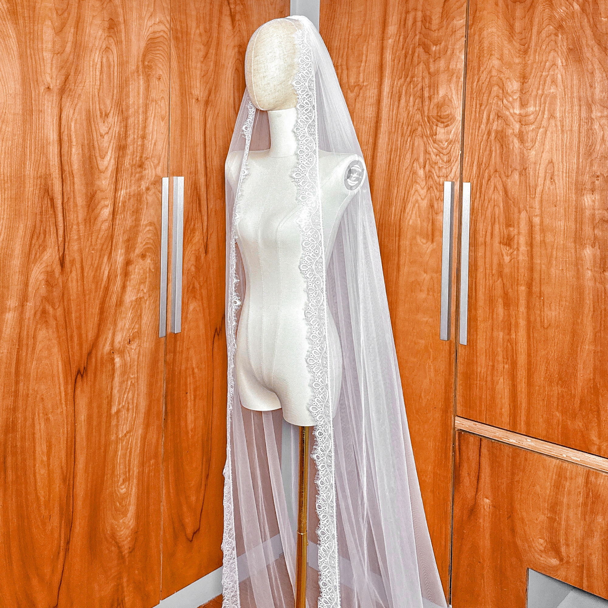 Cathedral length wedding veil featuring a scalloped Chantilly lace floral border.