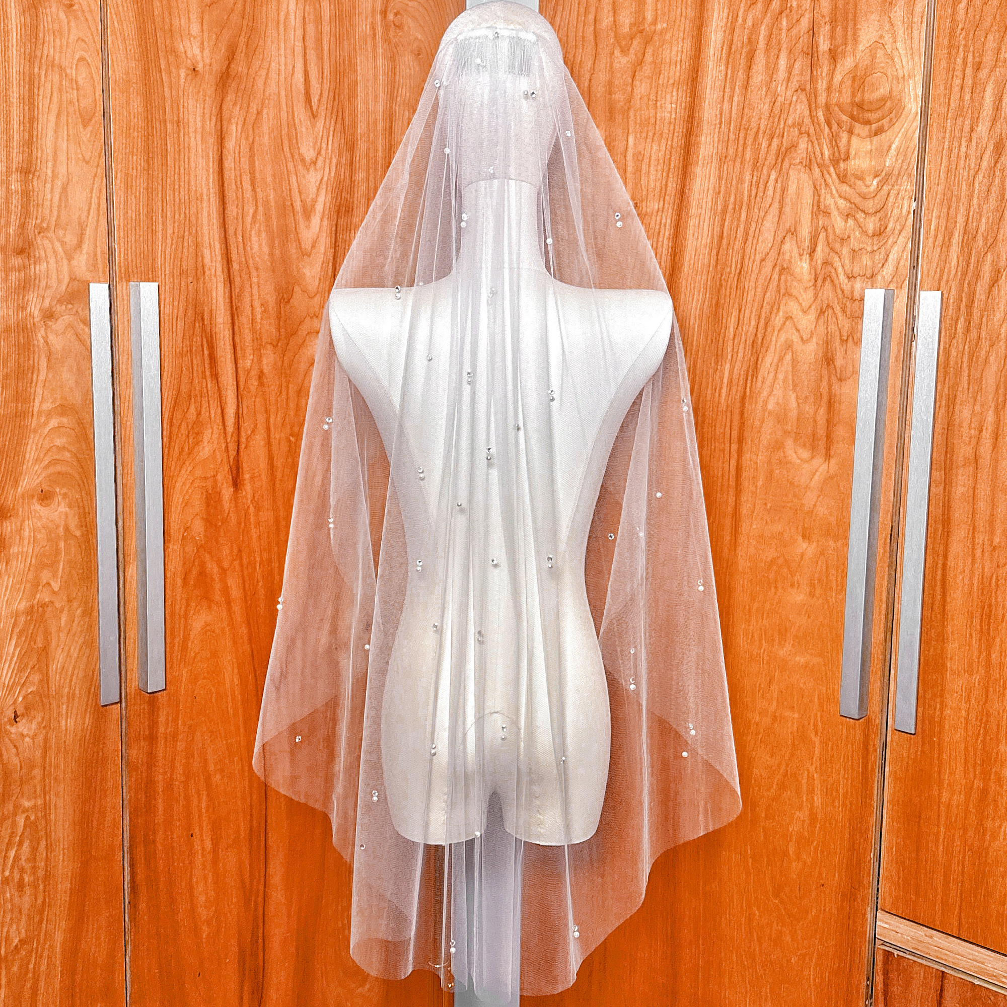 Back view showing the elegant drape of the sheer tulle scattered pearl and rhinestone wedding veil.