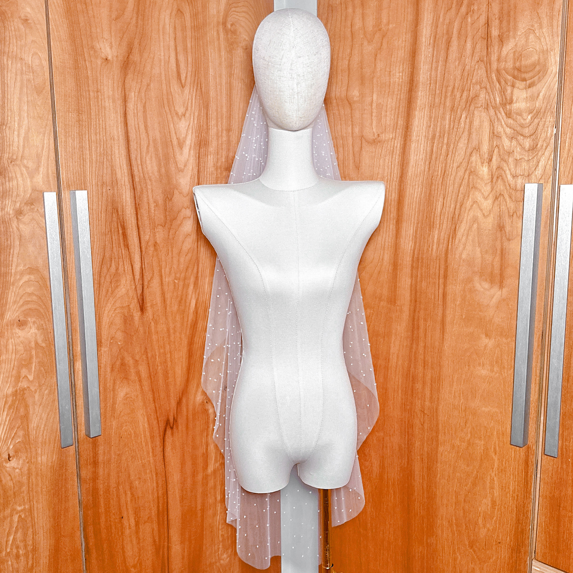 Knee-length scattered pearl blusher veil on a mannequin with the front blusher layer lowered, showing the coverage and starlit pearl effect.