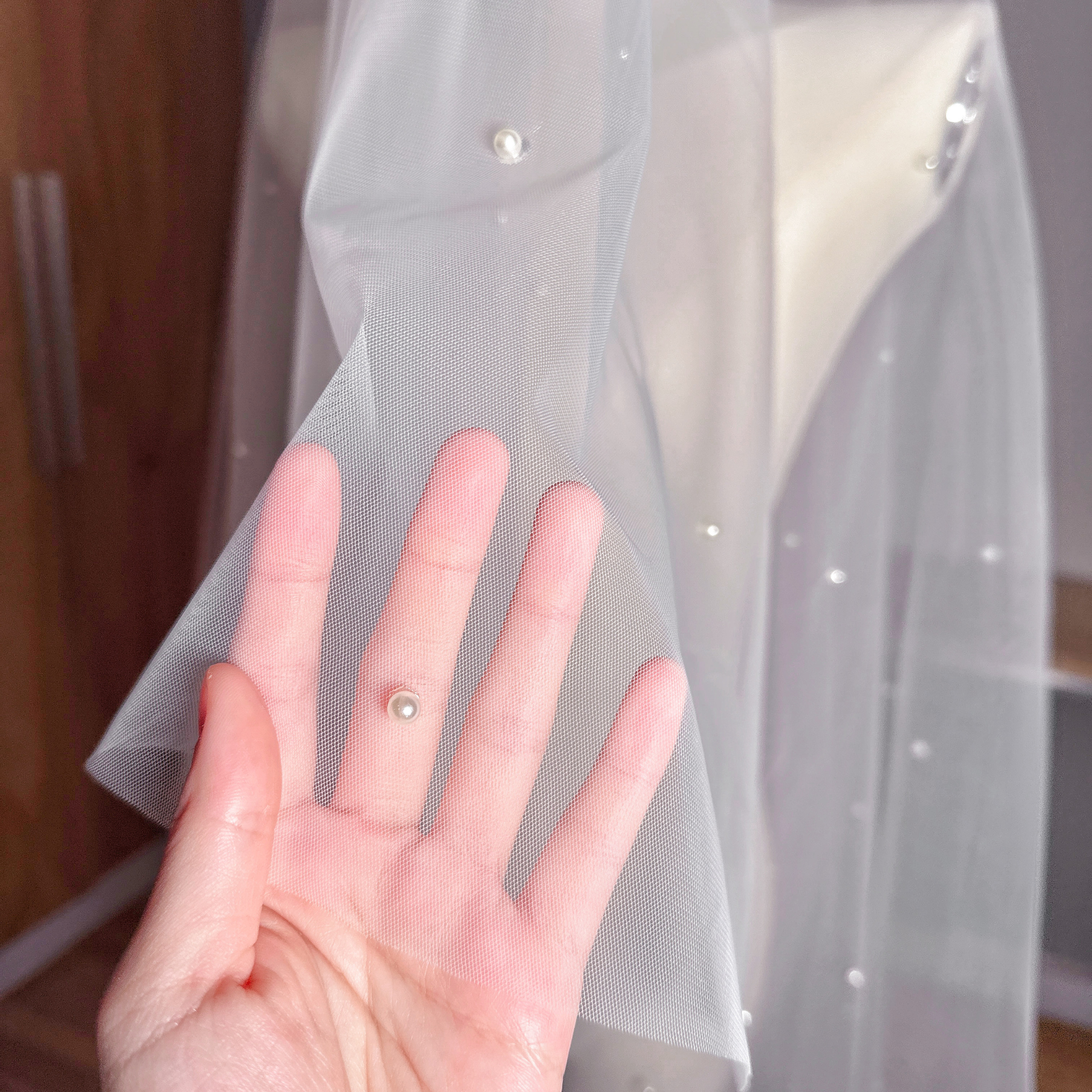 Close-up of a two tier scattered pearl wedding veil showing the delicate drop veil style.