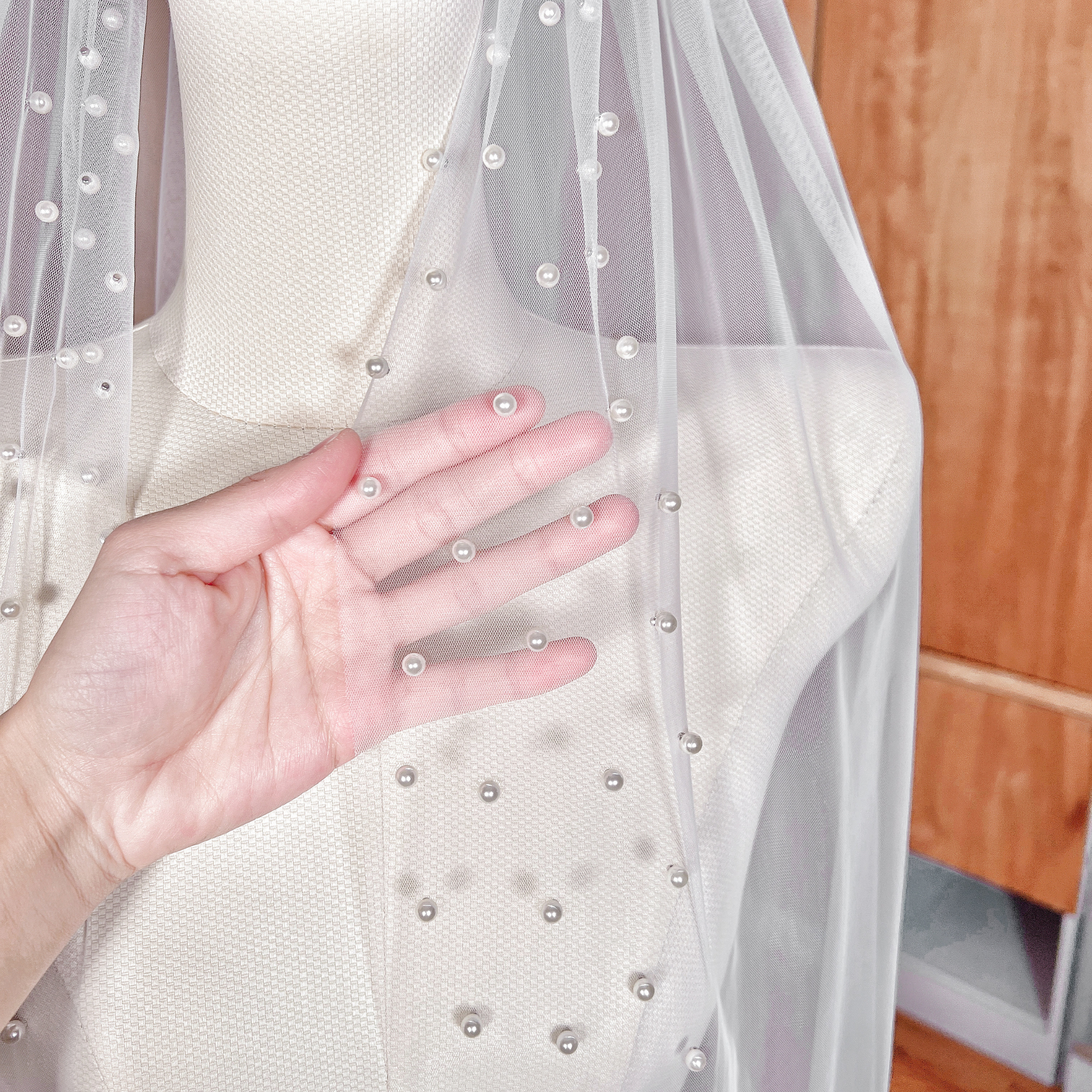 Close-up of the delicate hand-sewn pearl details on the border of the Scattered Pearl Edge Wedding Veil.