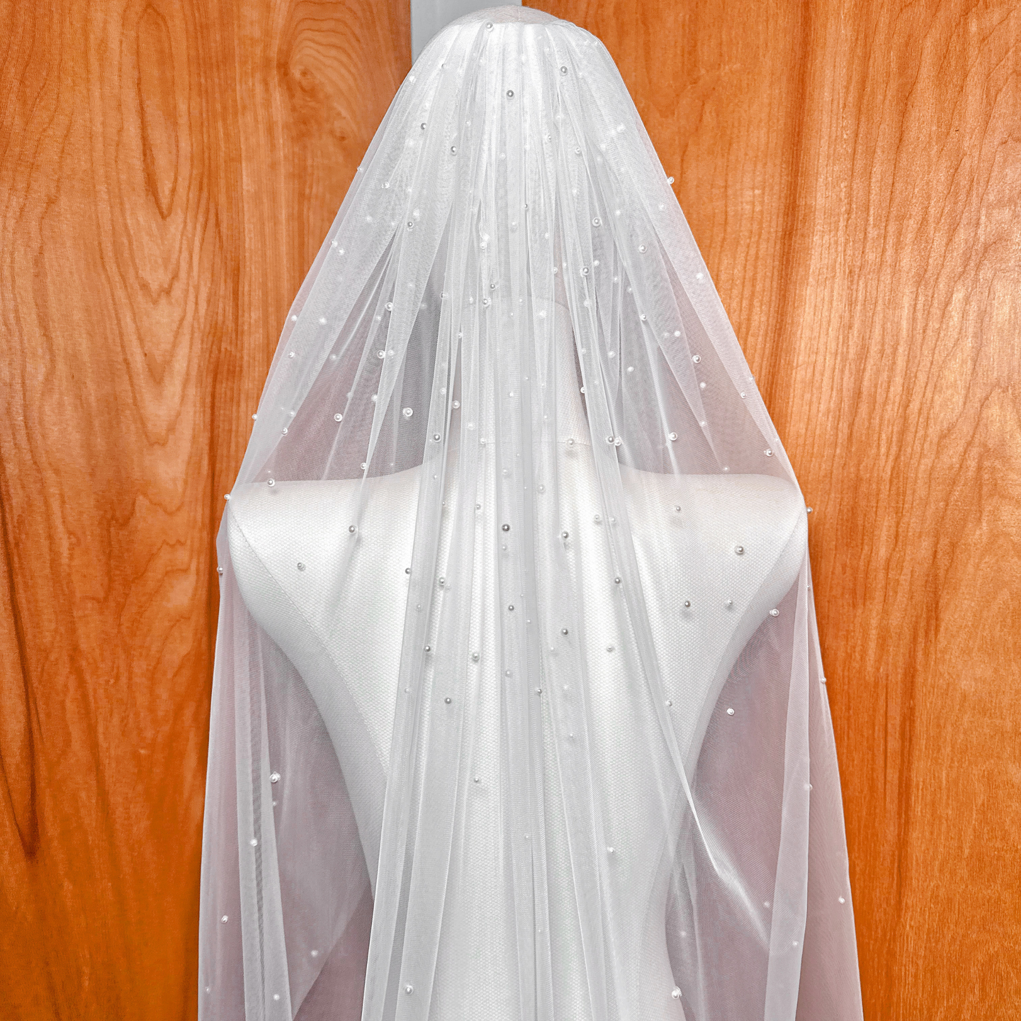 Macro shot of the hand-placed pearl embellishments on the scattered pearl fingertip length veil.