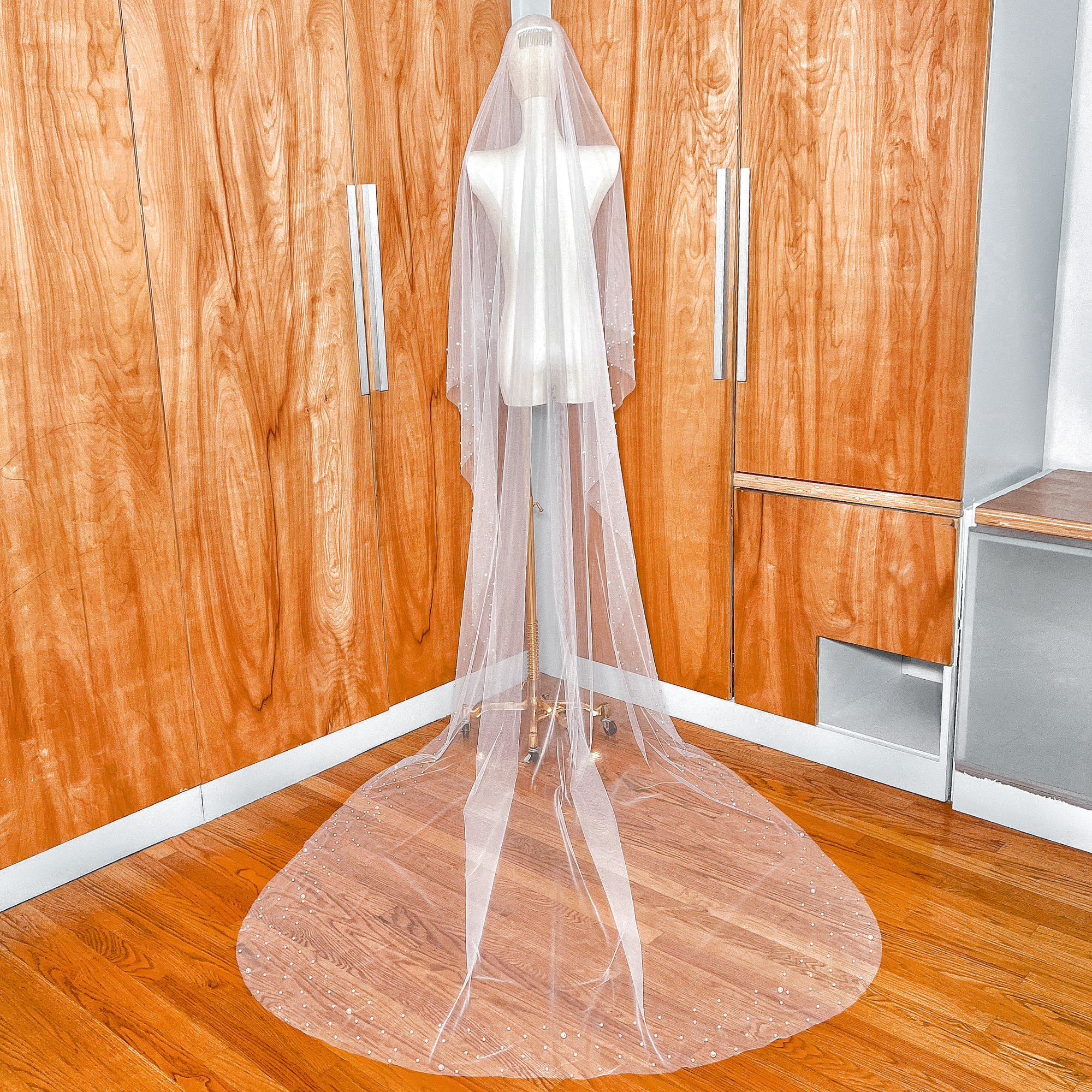 Delicate pearl embellishments on a two tier scattered pearl wedding veil made of soft tulle.