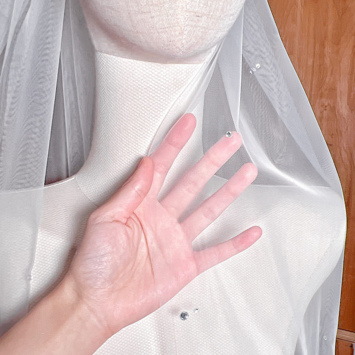 Detailed close-up of shimmering rhinestones on a scattered rhinestone wedding veil.