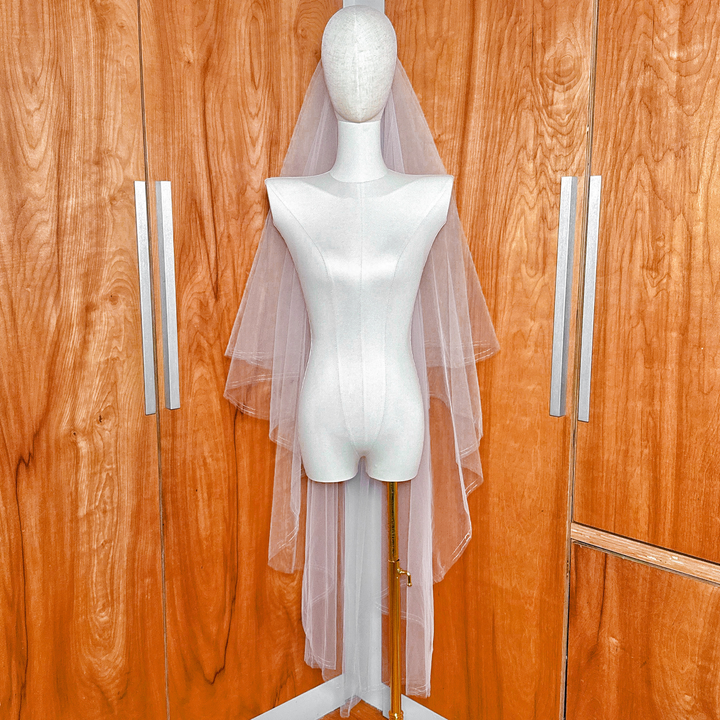 Clear view separating the blusher layer from the waltz length layer of a two tier wedding veil with rose gold metallic edge.