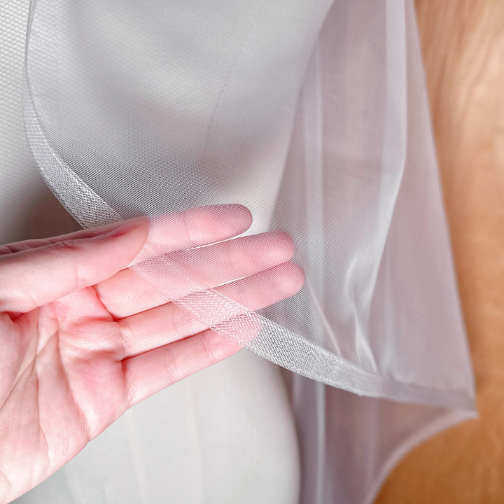 Close-up of the 1/2-inch horsehair trim on a sheer cascade waltz veil, draped elegantly over a bridal mannequin.