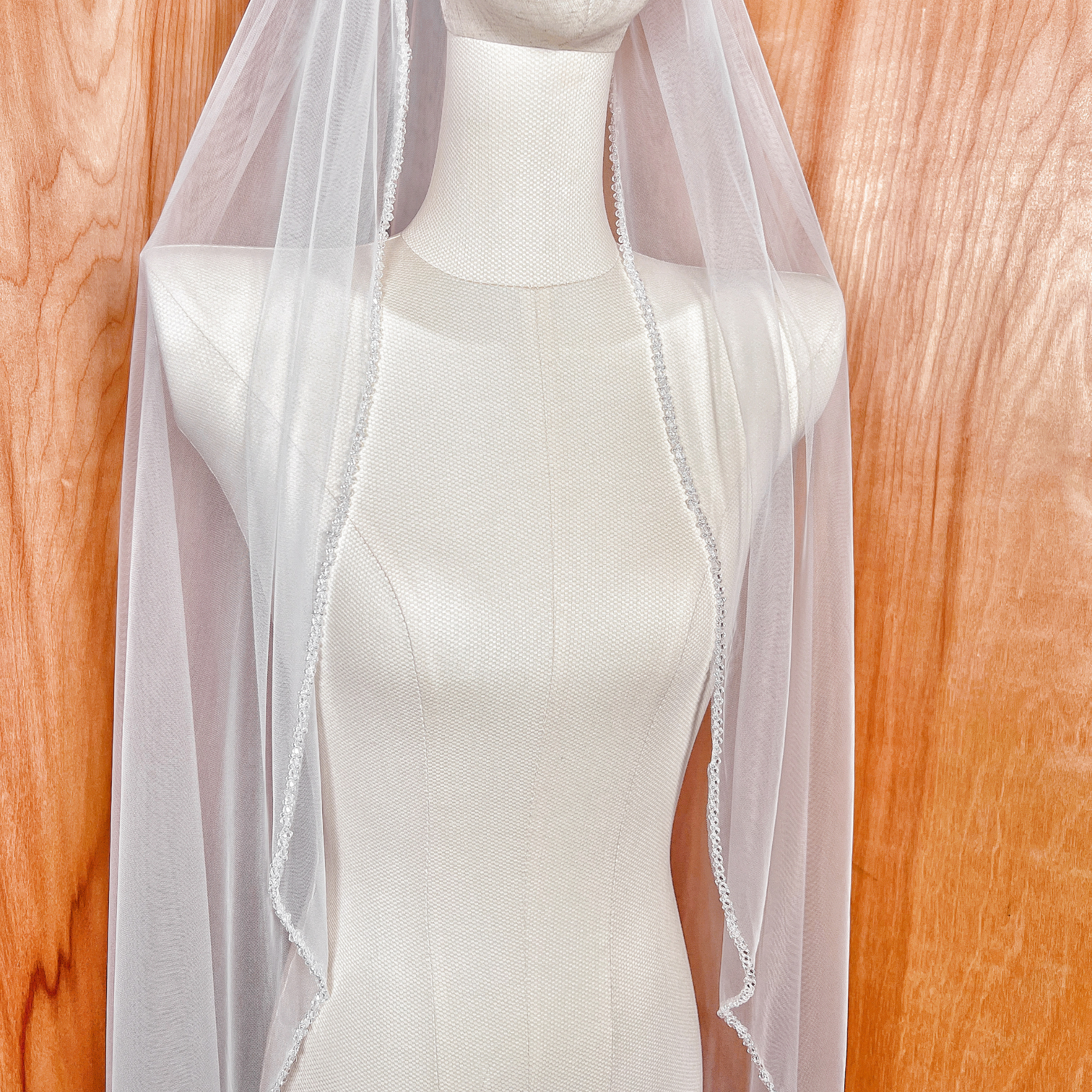 Elegant crystal beaded wedding veil falling perfectly to fingertip length.