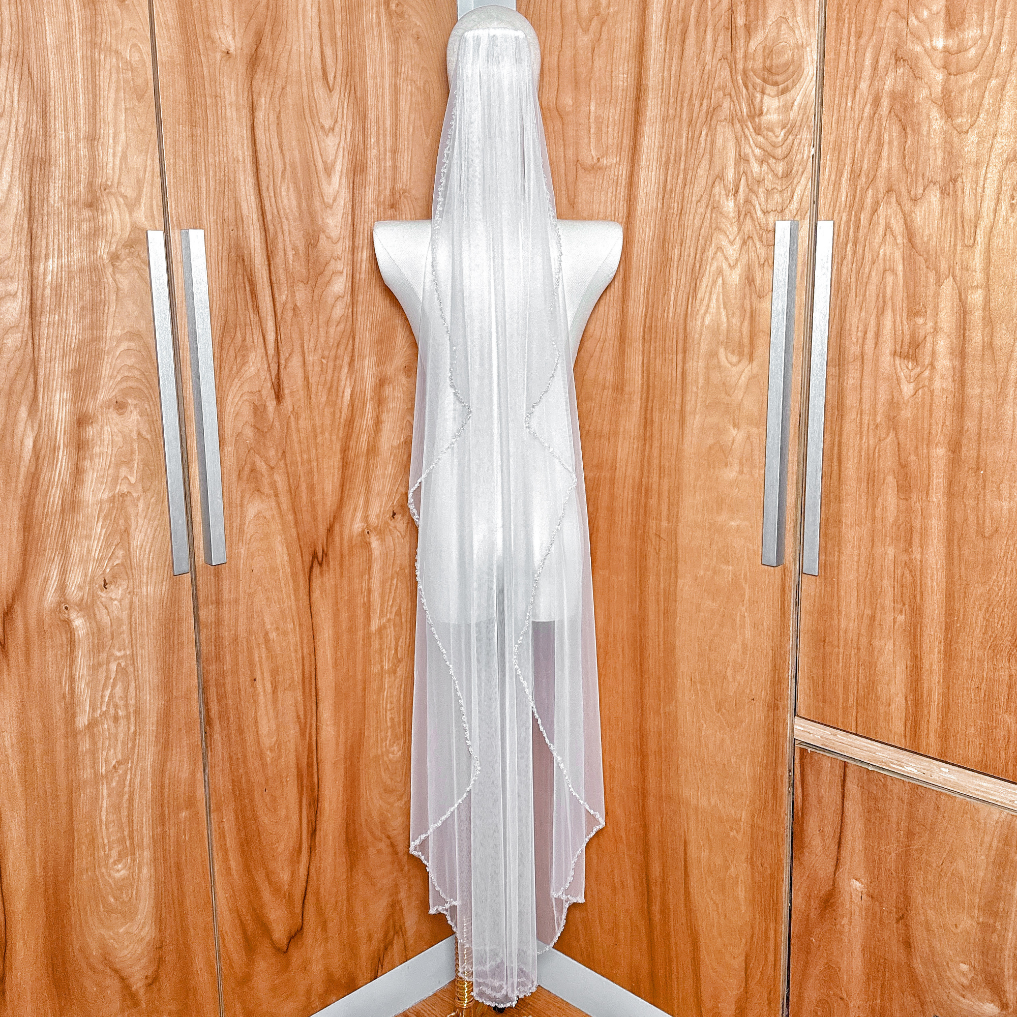 Detailed texture of the sheer bridal tulle and crystal beaded edge wedding veil in waltz length.
