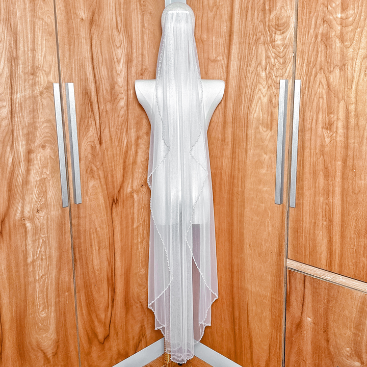 Detailed texture of the sheer bridal tulle and crystal beaded edge wedding veil in waltz length.