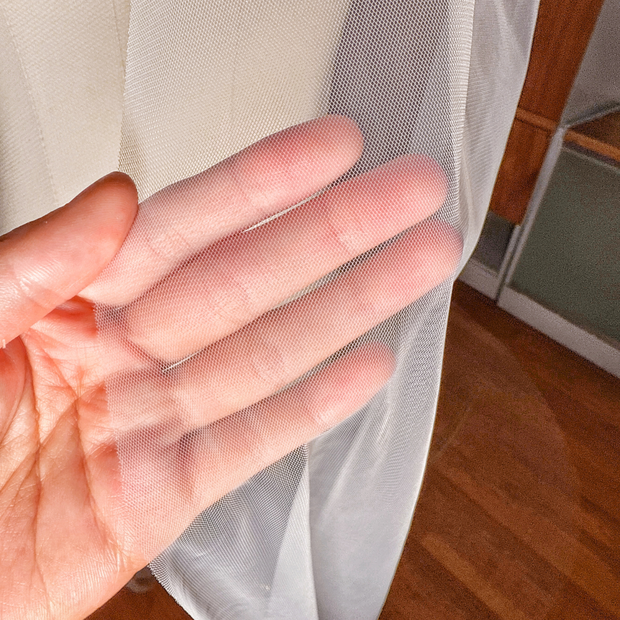 Close-up of the delicate sheer tulle and minimalist raw edge on a Royal Cathedral length wedding veil.
