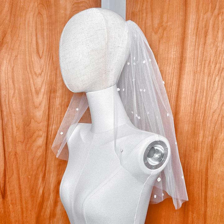 Angled side view showing the soft, airy drape and cascade of the floral elements around the shoulders.