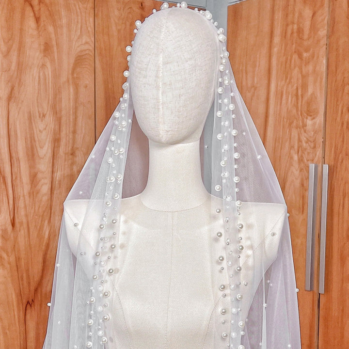 Side profile of the scattered pearl edge mantilla wedding veil in cathedral length shown on a mannequin to display the drape.