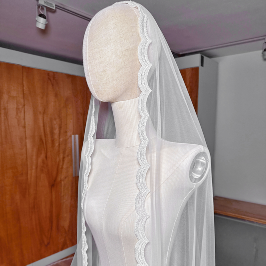 Side profile of a beaded mantilla wedding veil in royal cathedral length demonstrating how the sheer tulle and beaded trim drape over the shoulders.