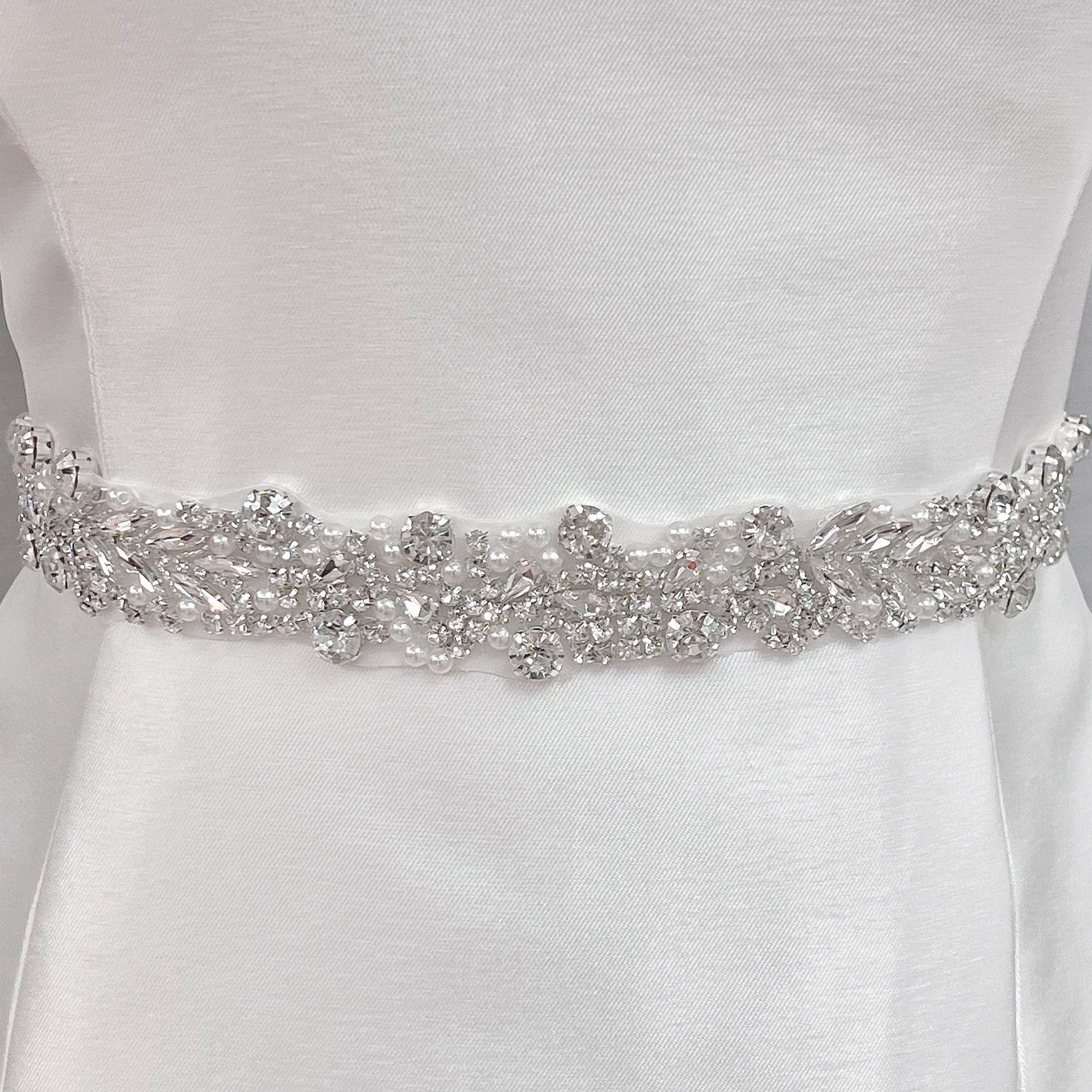 A close-up shot of a 1.2-inch wide silver beaded bridal belt displayed on a mannequin.