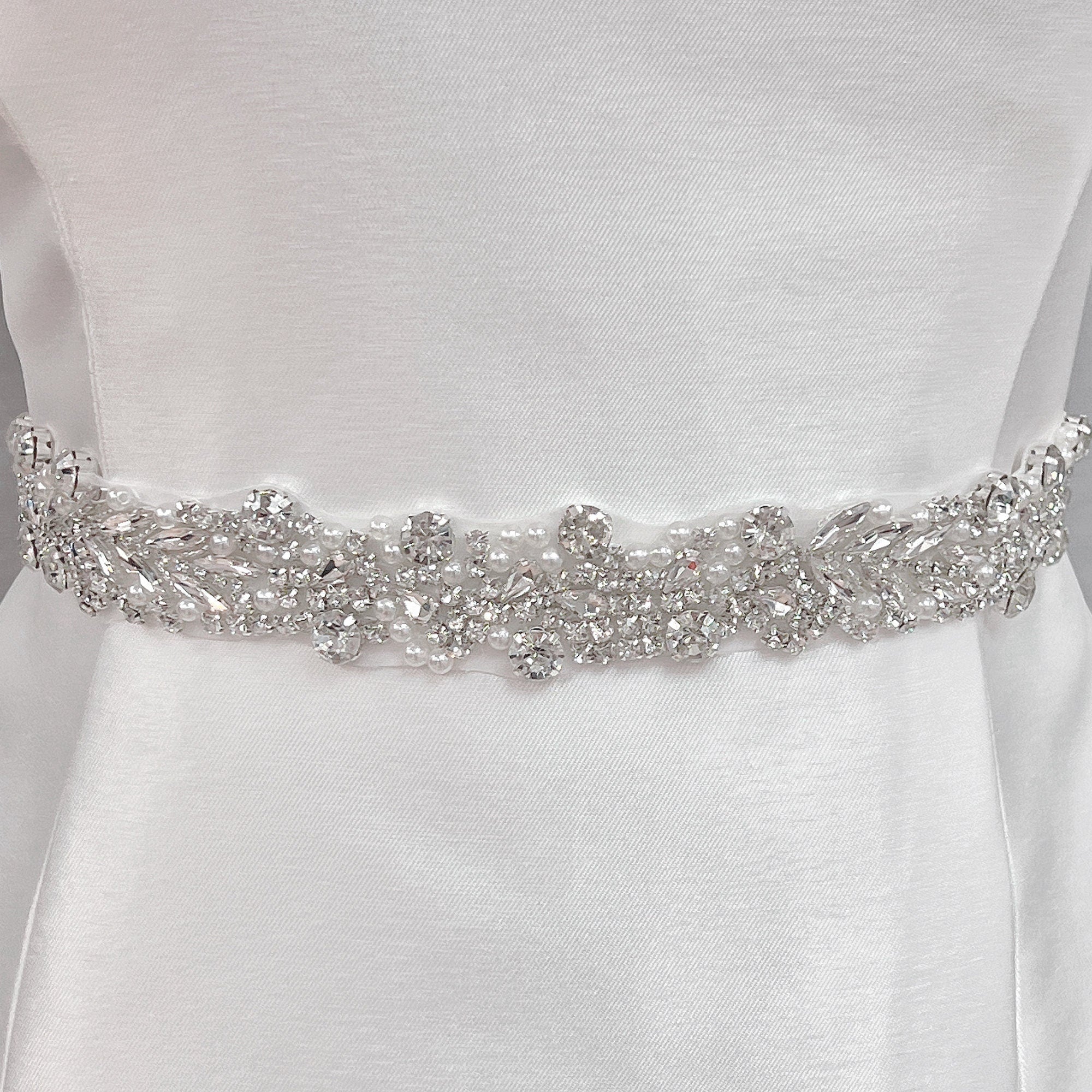 A close-up shot of a 1.2-inch wide silver beaded bridal belt displayed on a mannequin.