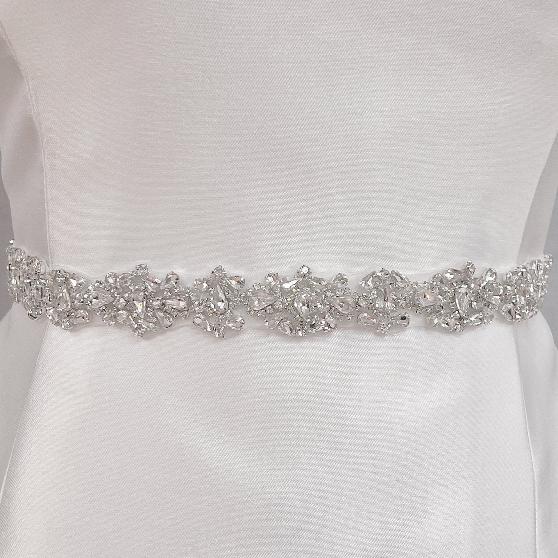 Close-up detail of the intricate crystal rhinestone beadwork on the silver beaded bridal belt.